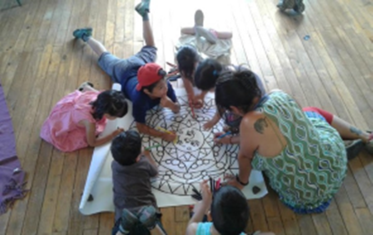 picture of students in a circle with a teacher